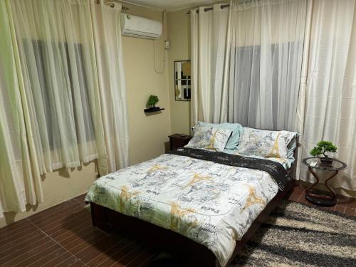 a bedroom with a bed in a room with windows at Raqsea House in Monrovia