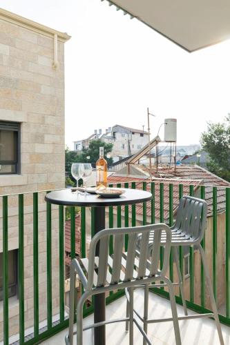 a patio with a table and chairs on a balcony at The J Luxury Apartments Near Mahane Yehuda - Perfect for Shabbat Stays in Jerusalem
