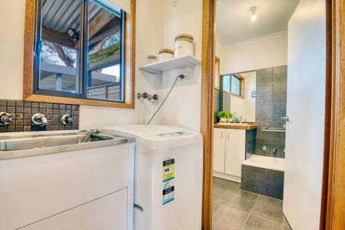 a small kitchen with a sink and a refrigerator at The Deck @ VB - Linen, Wi-Fi, Pets, Secured Yard in Venus Bay