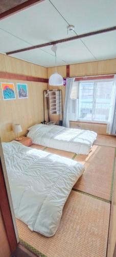 a bedroom with two beds and a window at The Lodge In Sapporo in Sapporo