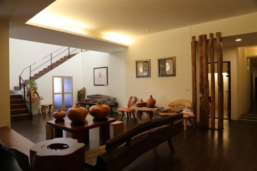 a living room with vases on tables and a staircase at Romeo B&B in Taitung City