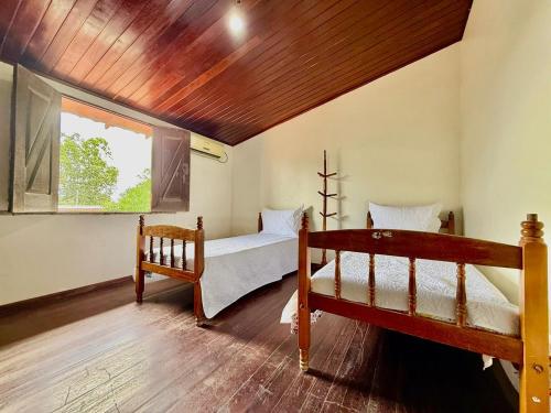 a bedroom with two beds and a window at Refúgio Santarém in Barreirinhas