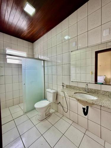 a bathroom with a toilet and a sink and a mirror at Refúgio Santarém in Barreirinhas