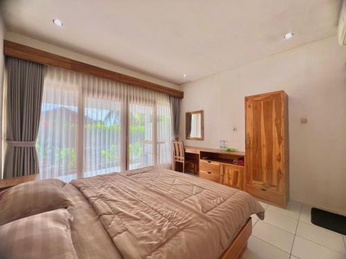 a bedroom with a bed and a desk and a window at The sonteng hills in Sengkol