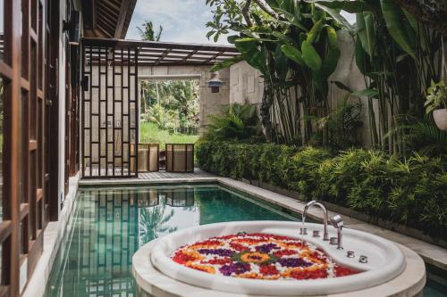 a pool with a bath tub in the middle of a house at Asvara Villa Ubud by Ini Vie Hospitality in Ubud