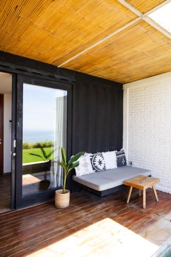 a bedroom with a bed and a table and a window at Telescope Villas Lombok in Kuta Lombok