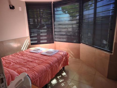 a bedroom with a bed with towels on it at Cabaña con parque en Tupungato in Tupungato