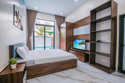 a bedroom with a large bed and a television at LakeView Villa BT43-03 Sầm Sơn in Sầm Sơn