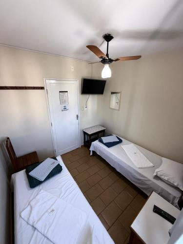 a room with two beds and a ceiling fan at Modenesi Hotel in Linhares