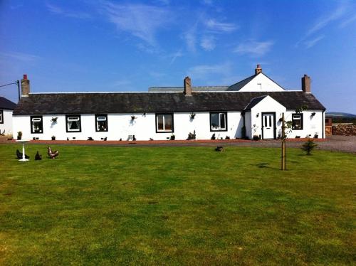 duży biały dom z zielonym polem przed nim w obiekcie Broadlea of Robgill Country Cottage & Bed and Breakfast w mieście Ecclefechan