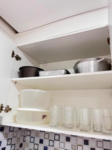 a kitchen with empty shelves with pots and pans at Morada dos Pássaros - Casa - 3 quartos e garagem in Vitória da Conquista
