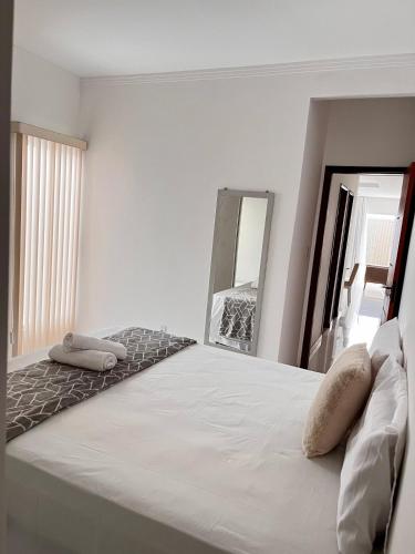 a bedroom with a large bed with two pillows on it at Morada dos Pássaros - Casa - 3 quartos e garagem in Vitória da Conquista