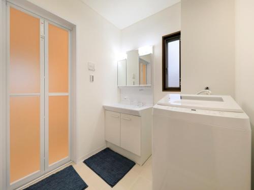 a white bathroom with a sink and a mirror at Knowledge House in Odawara