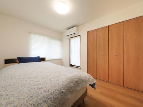 a bedroom with a bed and a wooden cabinet at Knowledge House in Odawara