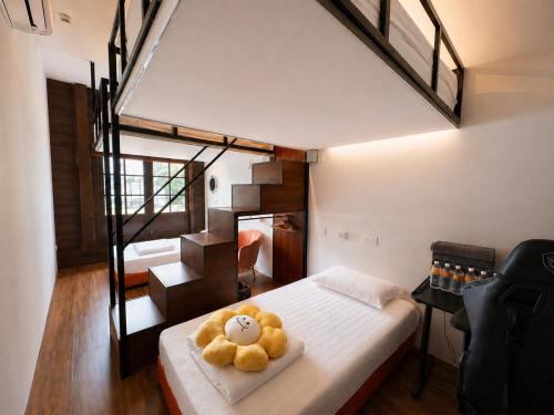 a teddy bear sitting on a bed in a bedroom at Bugis Social-Newly Renovated in Singapore