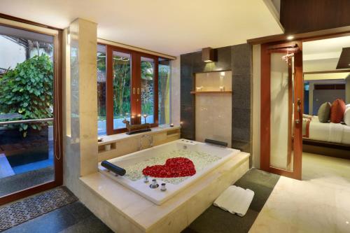 a large bathroom with a tub filled with red rocks at Royal Kamuela Villas & Suites at Monkey Forest Ubud - Adult Only in Ubud