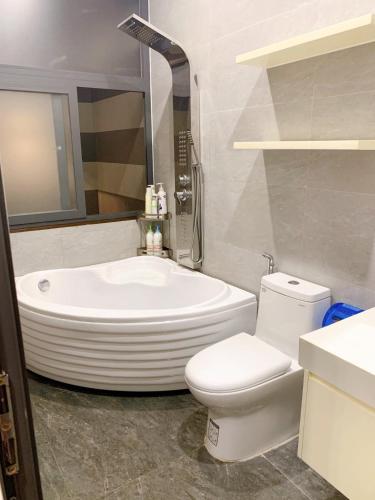 a bathroom with a tub and a toilet and a sink at Hotel Tâm Đan in Ðông Tác (1)
