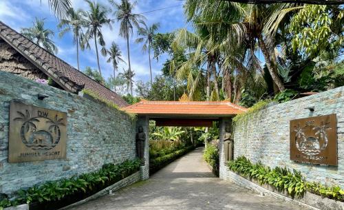 a walkway through a brick wall with a doorway at DW Jungle Resort - Candidasa in Candidasa