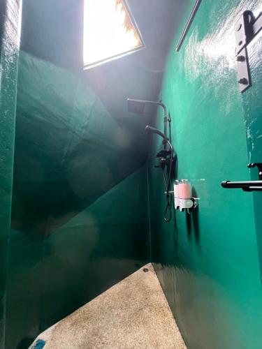 a bathroom with a green wall and a window at Coconest THREE Langkawi in Tanjung Rhu