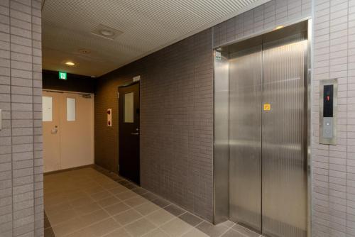 a hallway with two elevators in a building at 匯金中葛西ビル in Tokyo