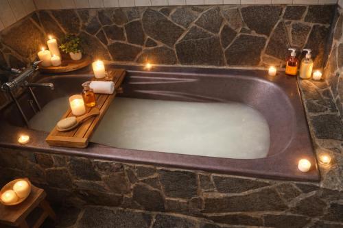 ein Badezimmer mit einer Badewanne voller Kerzen in der Unterkunft Amoria in Miyazaki
