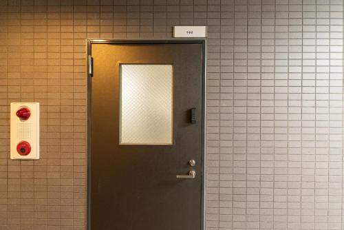 a door in a restroom with a mirror on it at 匯金中葛西ビル in Tokyo