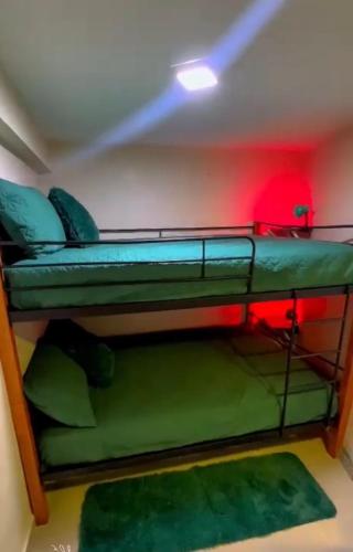 ein Schlafzimmer mit zwei Etagenbetten in Grün und Rot in der Unterkunft Rinconcito verde in Constanza