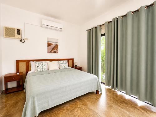 a bedroom with a bed and a large window at Villas Flora Bella Sunflower in Dauis