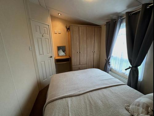 a small bedroom with a bed and a window at C43 The Hideout in Rowen