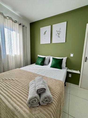 a bedroom with two beds with towels on them at Apartamento 2 Quartos Aconchegante - Ar Condicionado nos Quartos - 1 Cama Casal - 2 Camas de Solteiro com Auxiliar - Cozinha Completa - Estacionamento Gratuito in Três Lagoas