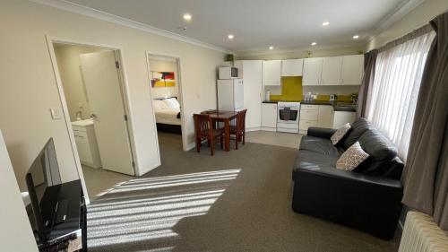 a living room with a couch and a kitchen at Crow's Nest in Picton