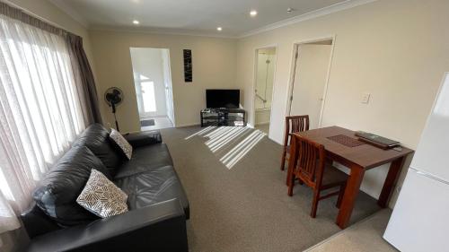 a living room with a couch and a table at Crow's Nest in Picton