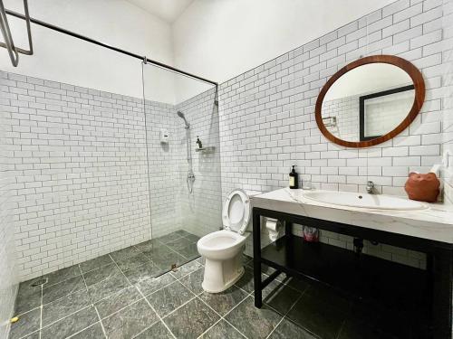a bathroom with a sink and a toilet and a mirror at Suite Room The Megatruh in Kejayan