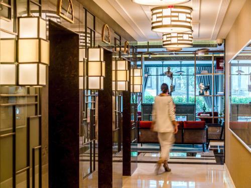 a woman walks through the lobby of a store at The Artisan Hotel Istanbul - MGallery Collection in Istanbul