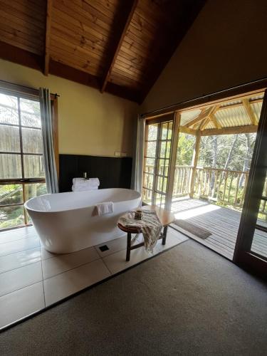 a large bathroom with a tub and a large window at Lemonthyme Wilderness Retreat in Moina