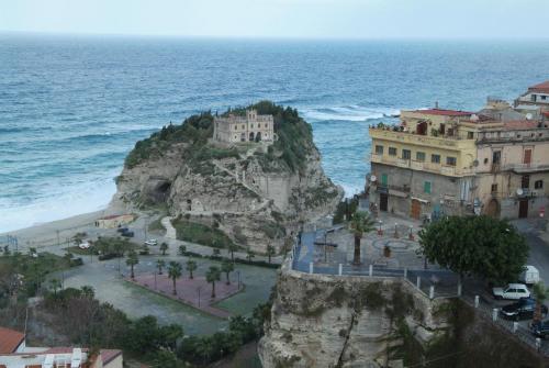 a building on a cliff next to the ocean at Hotel Alexander in Tropea