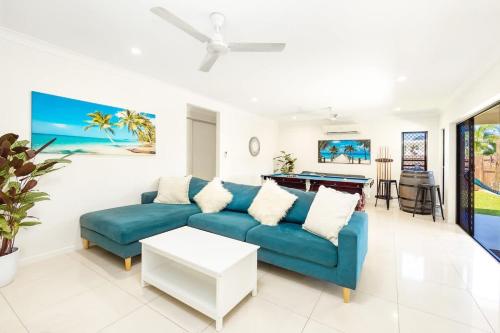 a living room with a blue couch and a table at Tropical Dreams - Spacious Retreat with Private Pool in Smithfield