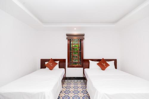 two beds in a room with a window at Cong Hoa Homestay in Vũ Lâm