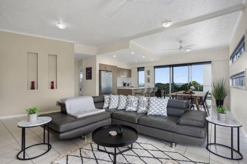 a living room with a couch and a table at Panorama Cairns - City & Coastal Views with Pool in Cairns