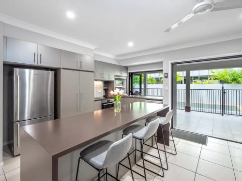 a kitchen with a large dining table and chairs at Tropical Pool Sanctuary in Kewarra Beach, Family and Dog Friendly in Kewarra Beach