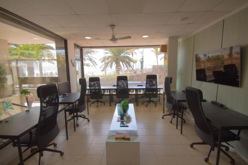 a conference room with tables and chairs in an office at Hostel Tropical Work in Las Palmas de Gran Canaria