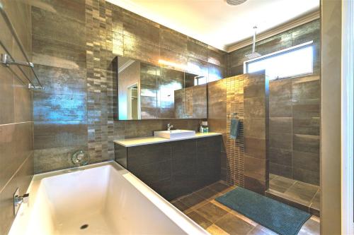 a bathroom with a bath tub and a sink at Marina Views Mindarie in Mindarie