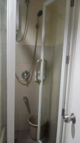 a bathroom with a shower with a toilet and a sink at Janeeka's Airie Avida Riala Cebu in Cebu City