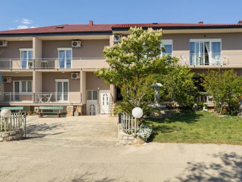 a large apartment building with a courtyard and a tree at Tinka, Zimmer No 2 in Starigrad