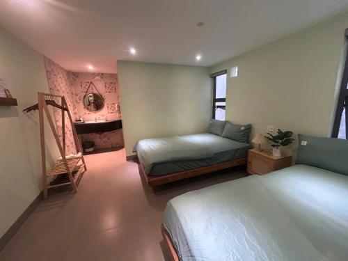 a bedroom with two beds and a desk in it at Lemon House in Quy Nhon