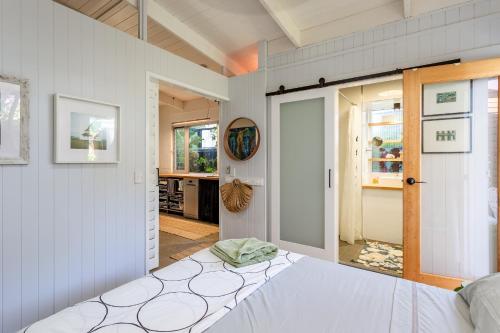 a bedroom with a white bed and a door at Studio 55 in Mudjimba
