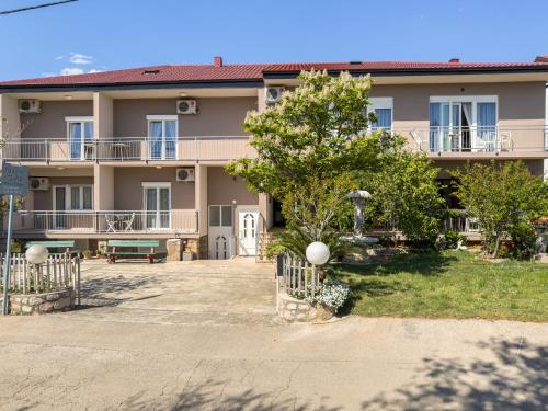 a large apartment building with a tree in front of it at Tinka, Zimmer No 5 in Starigrad