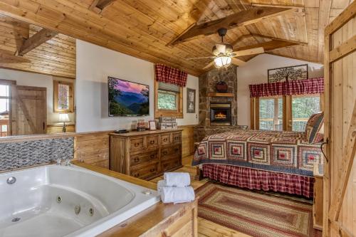 a log cabin bedroom with a bed and a tub at Mountain Dreams in Sevierville