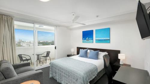 a bedroom with a bed and a living room at 'The Sand Dollar' Central Cairns Chic with Adjacent Studio in Cairns