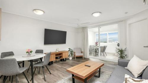 a living room with a table and a dining room at 'The Sand Dollar' Central Cairns Chic with Adjacent Studio in Cairns